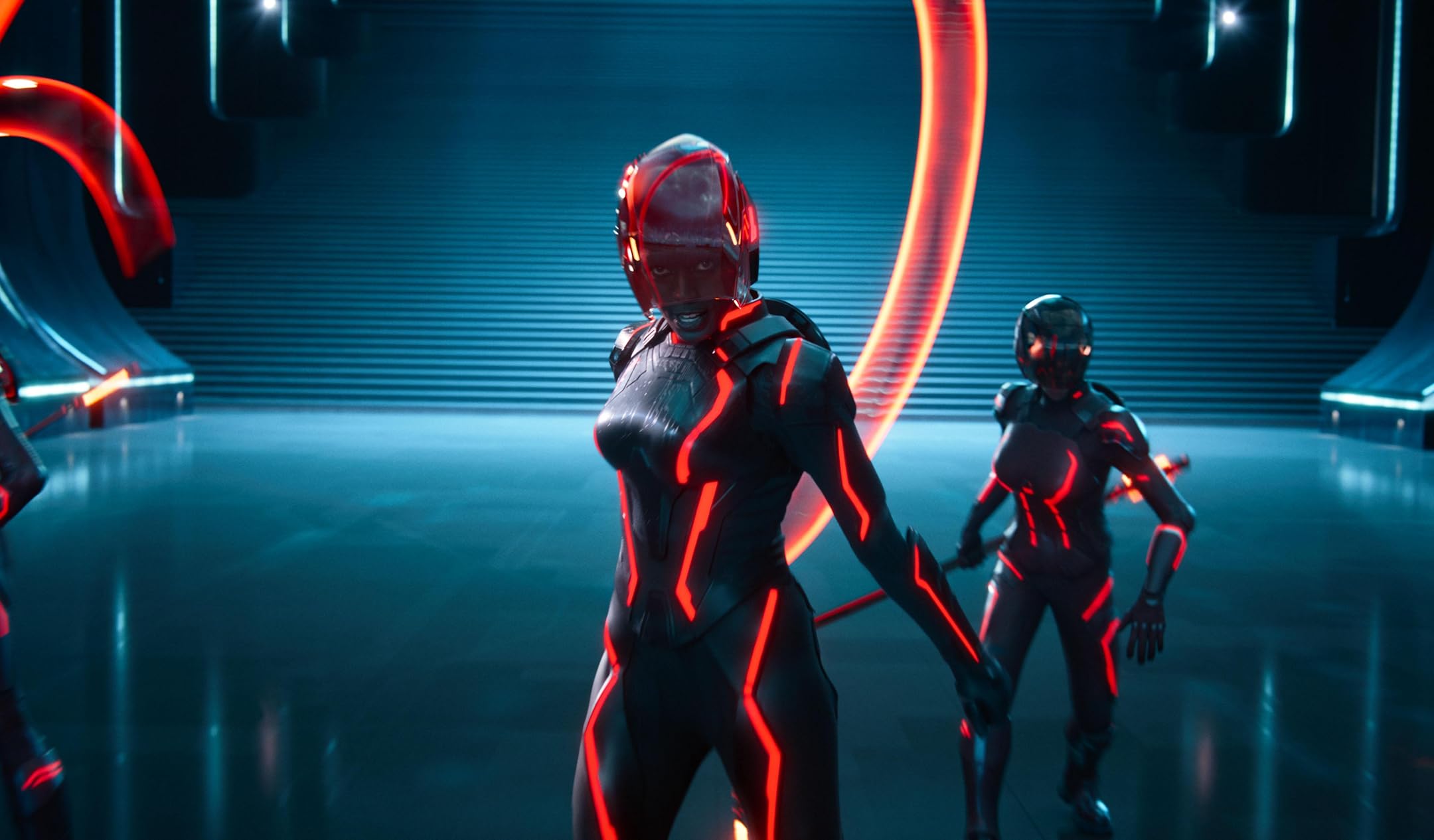 Tron character in a red neon suit preparing for battle inside a digital arena.